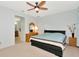 Bedroom with ceiling fan, light walls, dresser and a peek of a bathroom at 718 Tanana Fall Dr, Ruskin, FL 33570