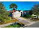 Well-kept single-story home with a two-car garage, lush lawn, and mature trees at 718 Tanana Fall Dr, Ruskin, FL 33570