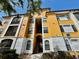 Inviting condo building featuring yellow walls, white trim and an entryway staircase to upper floors at 8397 38Th Street E Cir # 306, Sarasota, FL 34243