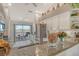 Bright kitchen with stainless steel appliances, granite countertops, and an adjacent balcony offering outdoor views at 9499 Millbank Dr # 2722, Sarasota, FL 34238