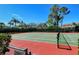 Outdoor tennis court in a well-maintained community surrounded by lush landscaping and blue skies at 9499 Millbank Dr # 2722, Sarasota, FL 34238