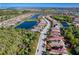 Aerial view of a neighborhood featuring homes with tile roofs, a nearby lake, and lush landscaping at 9902 Craftsman Park Way, Palmetto, FL 34221