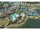 Aerial view of community amenities including a large pool, tennis courts, parking and surrounding buildings and landscaping at 9902 Craftsman Park Way, Palmetto, FL 34221