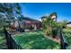 Landscaped backyard with fenced perimeter, screen enclosed pool, manicured lawn, and red umbrella at 9902 Craftsman Park Way, Palmetto, FL 34221