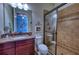 Well-lit bathroom with a granite countertop vanity and glass-enclosed shower at 9902 Craftsman Park Way, Palmetto, FL 34221