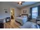 Relaxing bedroom with wood-look floors, a ceiling fan and en-suite bathroom access at 9902 Craftsman Park Way, Palmetto, FL 34221
