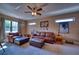 Comfortable bonus room featuring a leather sectional, ceiling fan and natural light at 9902 Craftsman Park Way, Palmetto, FL 34221