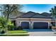 Home featuring a manicured lawn, lush landscaping, and a convenient two-car garage, perfect for modern living at 9902 Craftsman Park Way, Palmetto, FL 34221