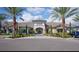 Beautiful clubhouse exterior with lush landscaping, mature palms, and ample parking at 9902 Craftsman Park Way, Palmetto, FL 34221