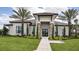 Clubhouse exterior with stone accents, manicured lawn, sidewalks and mature palms at 9902 Craftsman Park Way, Palmetto, FL 34221