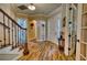 Inviting foyer with hardwood floors, a staircase, and a view into other rooms of the home at 9902 Craftsman Park Way, Palmetto, FL 34221
