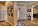 Inviting foyer with wood-look flooring, art-filled wall, and bright natural light from the front door at 9902 Craftsman Park Way, Palmetto, FL 34221