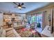 Bright living room featuring modern furniture, ceiling fan, and sliding glass doors leading to the pool area at 9902 Craftsman Park Way, Palmetto, FL 34221