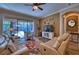 Cozy living room with sliding glass doors opening to a screened patio and pool at 9902 Craftsman Park Way, Palmetto, FL 34221