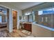Elegant main bathroom with wood floors, glass shower, and a vanity area at 9902 Craftsman Park Way, Palmetto, FL 34221