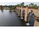 Unique community water feature featuring a stone bridge with flowing water and lush landscaping at 9902 Craftsman Park Way, Palmetto, FL 34221