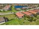 Neighborhood aerial shot features a home with a screened-in patio and lush landscaping near a community pond at 10008 Carnoustie Pl, Bradenton, FL 34211