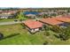Neighborhood aerial features two homes with screened-in patios and lush landscaping near a community pond at 10008 Carnoustie Pl, Bradenton, FL 34211