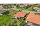 Aerial image captures home with tile roof and screened-in patio with neighborhood views near the pond at 10008 Carnoustie Pl, Bradenton, FL 34211