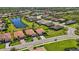 Picturesque neighborhood view showcases the serene pond and rows of neatly arranged homes with tile roofs at 10008 Carnoustie Pl, Bradenton, FL 34211