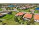 Aerial view showcases two homes with tile roofs and screened-in patios in a lush community near the pond at 10008 Carnoustie Pl, Bradenton, FL 34211