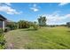 Backyard view features a pond surrounded by lush greenery and a spacious lawn at 10008 Carnoustie Pl, Bradenton, FL 34211