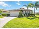 Charming single-story home featuring a tile roof, paved driveway, well-manicured lawn and beautiful landscaping at 10008 Carnoustie Pl, Bradenton, FL 34211