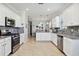 Bright kitchen features stainless appliances, granite counters, white cabinets, and tile backsplash at 10008 Carnoustie Pl, Bradenton, FL 34211