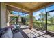 Screened-in lanai boasts brick flooring with comfortable seating and a view of the pond at 10008 Carnoustie Pl, Bradenton, FL 34211