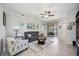 Bright living room with neutral walls, tile flooring, modern ceiling fan, and sliding doors to the outside at 10008 Carnoustie Pl, Bradenton, FL 34211