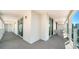A long, tiled balcony is complete with sliding glass doors and patio furniture at 101 S Gulfstream Ave # 16K, Sarasota, FL 34236