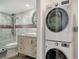 Convenient laundry area adjacent to a beautifully updated bathroom with stackable washer and dryer for space-saving efficiency at 101 S Gulfstream Ave # 16K, Sarasota, FL 34236