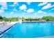 Brightly lit outdoor pool with clear blue water and surrounding greenery at 101 S Gulfstream Ave # 16K, Sarasota, FL 34236