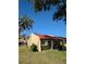 Charming tan home featuring a red tile roof, trimmed shrubs, and palm trees at 1216 58Th W St, Bradenton, FL 34209