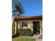 Charming home featuring a red tile roof, verdant shrubbery and beautiful palm trees against a clear blue sky at 1216 58Th W St, Bradenton, FL 34209