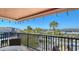 Relaxing balcony view with seating and a beautiful view of palm trees and neighboring buildings against a clear blue sky at 131 Garfield Dr # 4D, Sarasota, FL 34236