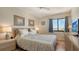 Well-lit bedroom with gray patterned bedding, side tables, and a large window offering a comfortable and stylish living space at 131 Garfield Dr # 4D, Sarasota, FL 34236
