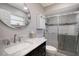 Bathroom features a marble top vanity, round mirror, and tiled shower with glass doors at 1325 Bottlebrush Dr, Bradenton, FL 34208