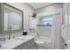 Bathroom features a marble top vanity, mirror, white cabinets, and tile shower with tub at 1325 Bottlebrush Dr, Bradenton, FL 34208