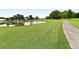 Picturesque view of the golf course featuring lush green fairway, a tranquil pond, and clear blue sky at 1325 Bottlebrush Dr, Bradenton, FL 34208