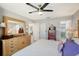 Comfortable bedroom boasts a ceiling fan, spacious dresser with mirror, and adjoining bathroom at 1325 Bottlebrush Dr, Bradenton, FL 34208