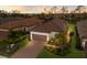 Aerial view of a single-story home with a tile roof, lush landscaping, and a brick driveway at 14651 Derna Ter, Bradenton, FL 34211