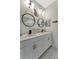 Bathroom featuring double sinks with matte black faucets and decorative round mirrors and wall art at 16966 Rosedown Gln, Parrish, FL 34219