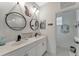 Bathroom featuring double sinks with matte black faucets and decorative round mirrors and wall art at 16966 Rosedown Gln, Parrish, FL 34219