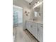 Bright bathroom features a white vanity with gray wood-look flooring and shower with blue curtain at 16966 Rosedown Gln, Parrish, FL 34219