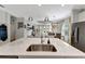 Bright kitchen featuring an island with stainless steel sink and faucet with an open concept view into the living room at 16966 Rosedown Gln, Parrish, FL 34219