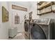 Laundry room with gray front load washer and dryer, with wood look tile flooring and decor at 16966 Rosedown Gln, Parrish, FL 34219