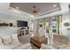 Bright living room featuring a ceiling fan, tile flooring, and a large television at 16966 Rosedown Gln, Parrish, FL 34219