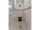 Tiled shower with a wooden bench and mosaic floor, accented with a chrome shower head and soap dish at 16966 Rosedown Gln, Parrish, FL 34219
