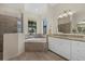 Bright bathroom with tub, walk-in shower, granite counters, and natural light at 17045 Polo Trl, Bradenton, FL 34211